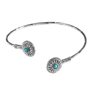 Vue détaillée d'un jonc ouvert vintage en argent avec gravures et pierres turquoise.