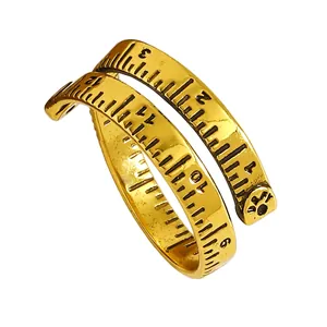 Nahaufnahme eines kreativen goldenen Maßbandrings mit gravierten Skalenmarkierungen.