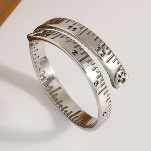 Detailaufnahme eines silbernen Maßband-Rings im Vintage-Stil mit gravierter Skala und Design