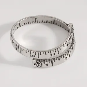 Makroansicht des Vintage-Maßbandrings mit detaillierten eingravierten Skalenmarkierungen
