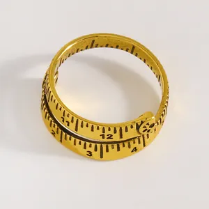 Nahaufnahme eines goldenen Vintage-Rings mit eingraviertem Maßband-Lineal-Design