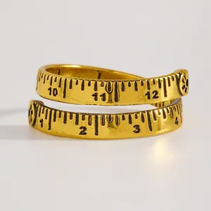 Nahaufnahme eines goldenen Maßbandrings mit eingravierter Skala und Zahlen im Vintage-Stil