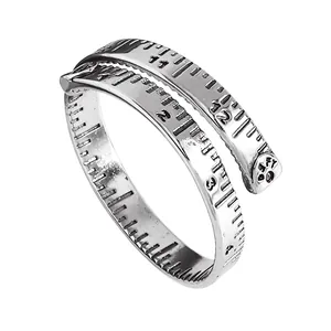 Detailansicht eines silbernen Maßband-Rings mit gravierten numerischen Skalen
