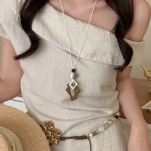 Elegant vintage long necklace featuring brown geometric pendant and white cord for summer
