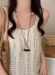 Close-up of retro long pendant necklace with wooden and ceramic beads on a model