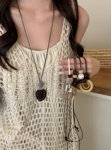 Close-up of retro style long pendant necklaces with wooden and geometric elements.