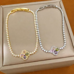 Elegante gouden en zilveren zirkonia klaverarmbanden gepresenteerd op een luxe juwelendoos