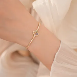 Macro-weergave van een elegante gouden klavertje vier armband met gekleurde zirkoon