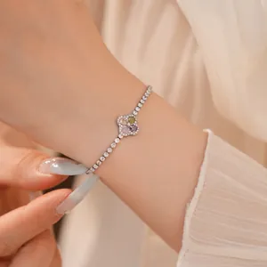 Elegante zilveren armband met klavertje vier en kleurrijke zirkoon om de pols gedragen