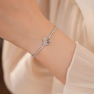 Detailweergave van een verzilverde klaverarmband met gekleurde zirkonia om een pols