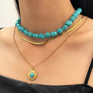 Detailed close-up of layered bohemian turquoise beaded choker and gold medallion necklace set