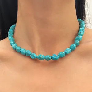 Close-up of turquoise beaded choker necklace on model's neck showing natural stone texture.
