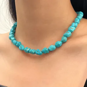 Close-up of a vibrant blue turquoise beaded necklace worn on a model's neck