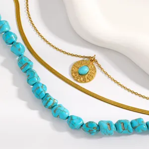 Close-up detail of multi-layered turquoise beaded necklace with gold snake chain