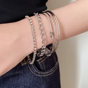 Elegante set di 5 bracciali argentati con strass e disegni a nodo per donna.