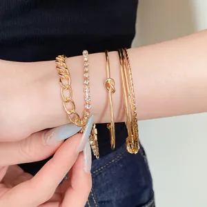 Primo piano di un set di 4 braccialetti dorati con strass e dettagli a nodo