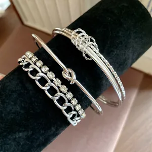 Set di 4 braccialetti argentati con catena di strass e dettaglio a nodo