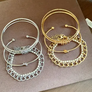Dettaglio di un set di quattro bracciali oro e argento con nodi e accenti di strass