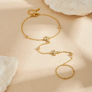 Elegante pulsera de mano con cruz de acero inoxidable dorado y circonitas brillantes.