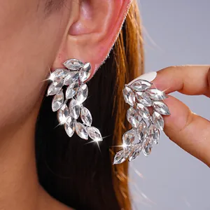 Detailed macro view of sparkling silver crystal feather wing stud earrings for women