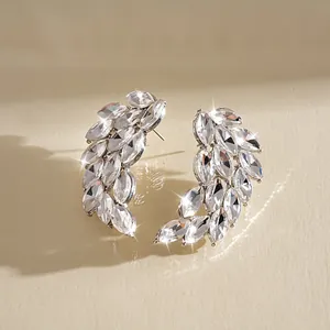 Close-up of sparkling feather stud earrings with marquise-cut crystals in silver.