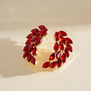 Detail view of elegant red marquise crystal feather wing earrings with gold setting.