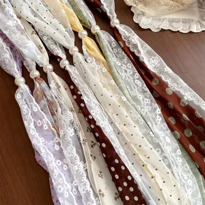 Detailweergave van kanten sjaalkettingen met bloemen en parels in zoete patronen.
