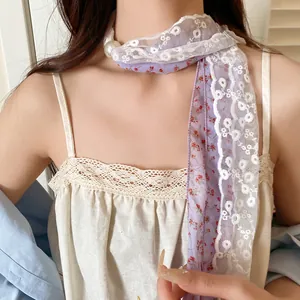 Close-up van elegante dubbellaagse kanten bloemensjaalketting met een grote parelaccent