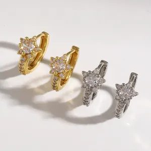 Close-up of star-shaped micro-pave cubic zirconia hoop earrings in gold and silver