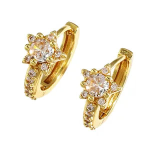 Detailed macro view of gold-tone star-shaped earrings with micro-paved crystals
