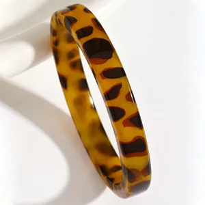 Close-up macro view of vintage resin bangle featuring classic amber tortoiseshell pattern