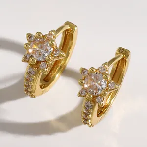 Close-up of elegant gold star huggie earrings with sparkling micro-pave crystals