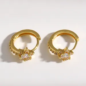 Close-up of elegant gold star-shaped huggie earrings with micro-inlaid sparkling CZ stones.