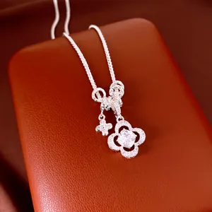 Primo piano di una collana con ciondolo a quadrifoglio in zircone su pelle marrone.