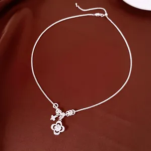 Vista ravvicinata di una collana a quadrifoglio in argento con zircone centrale