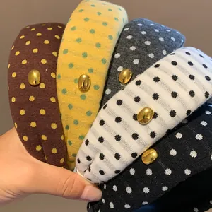 Gros plan de serre-têtes rétro à pois de différentes couleurs avec des détails dorés.