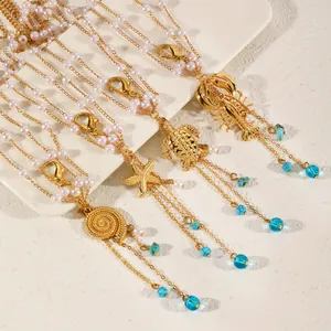 Close-up detail of golden ocean-themed body chains featuring starfish, shell, and pearl accents.