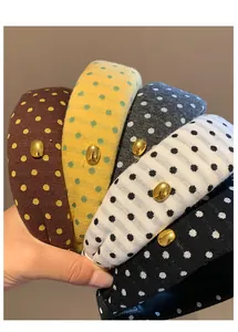 Vue détaillée de serre-têtes rétro à pois en cinq couleurs avec boucles dorées.