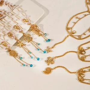 Detailed view of multilayer gold body chain with starfish and turquoise sea charms