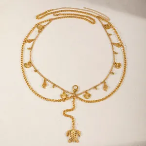 Close-up detail of the layered gold-tone body chain featuring shell and turtle charms