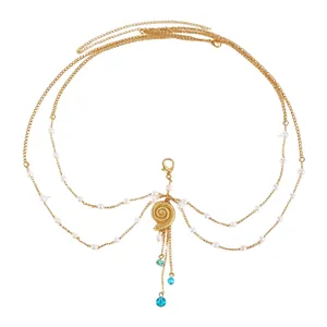 Detailed view of multilayer gold body chain with shell pendant and turquoise beads