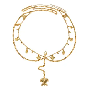 Detail of golden multi-layer body chain featuring seashell and sea turtle pendants