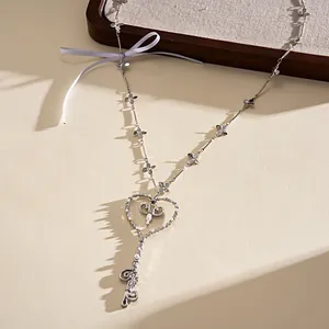 Vista detallada del collar con llave de corazón, perlas y un lazo azul de estilo elegante