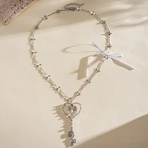 Vista detallada del collar llave corazón plata con cinta blanca y detalles florales