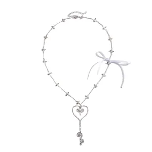 Elegante collar de llave de corazón plateado con eslabones de flores y lazo de cinta blanca raso