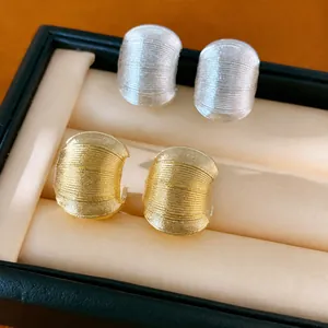 Boucles d'oreilles clous en métal texturé en forme de C en finitions or et argent.