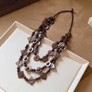 Detailed view of Bohemian layered necklace with dark brown wooden beads and coconut shells.