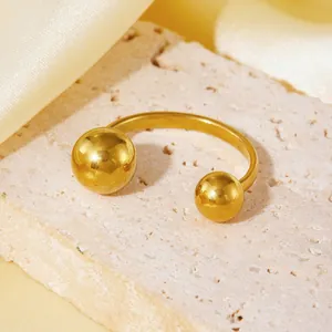 Nahaufnahme eines vergoldeten Edelstahlrings mit Kugelenden auf einem Steinuntergrund