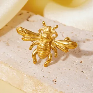 Nahaufnahme eines realistischen goldenen Bienenohrrings auf einem rustikalen Steinsockel