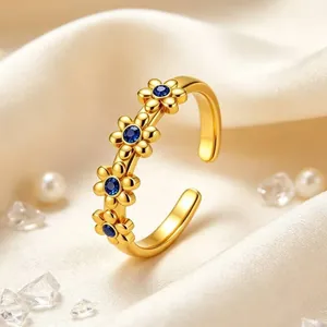 Detailansicht eines goldenen Ringes mit vier blauen Edelsteingänseblümchen